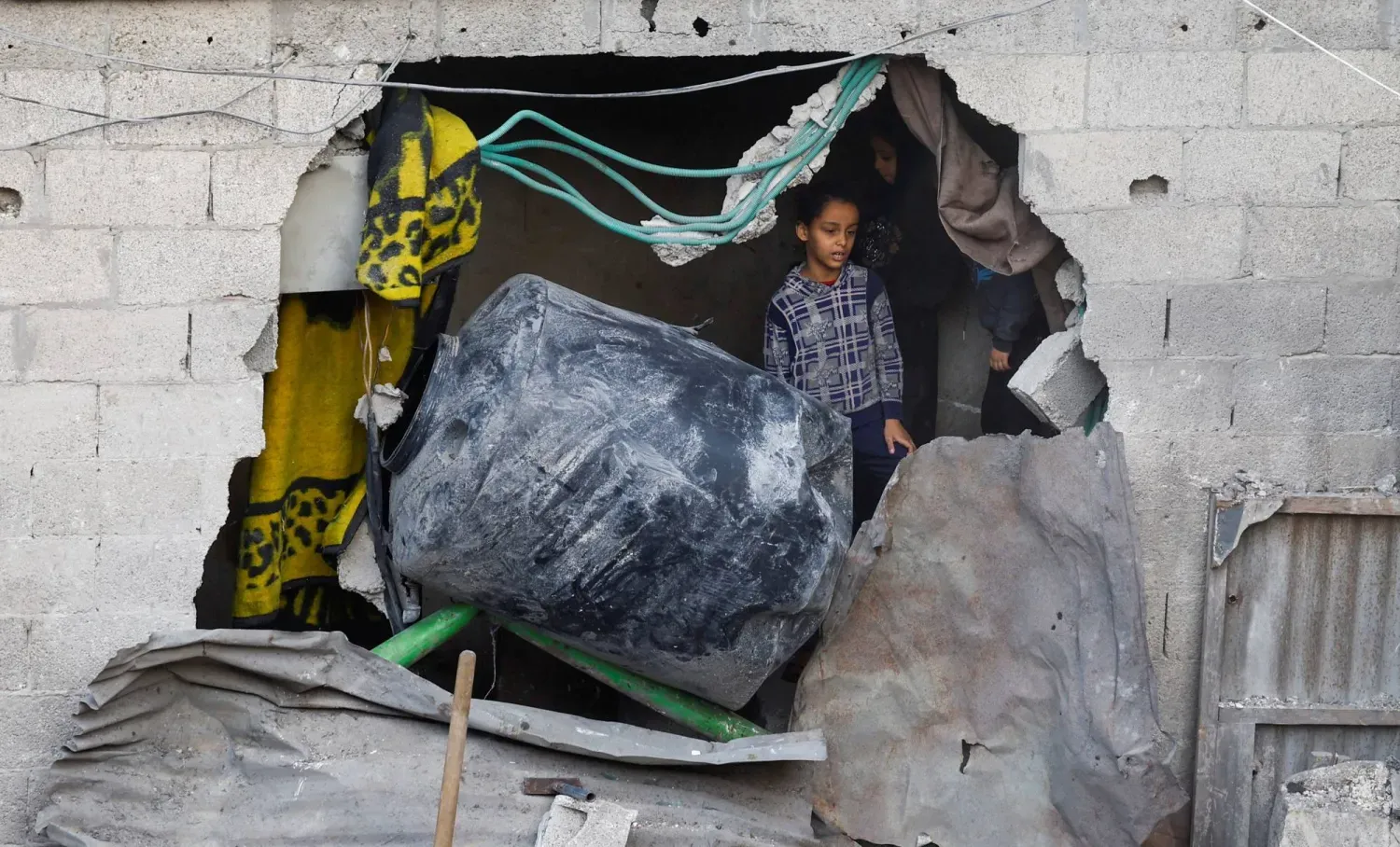 Gazze Şeridi'nin orta kesiminde İsrail ordusunun bombaladığı bölgeyi inceleyen Filistinli bir kız çocuğu, 22 Kasım 2025 (Reuters)