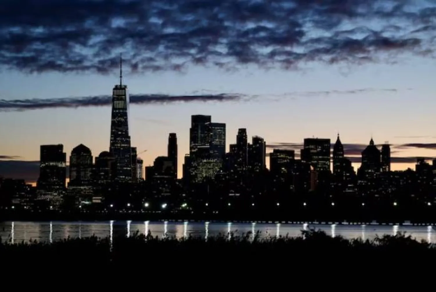أفق مانهاتن عند الفجر من ضفاف نهر هدسون في مدينة نيويورك (رويترز)