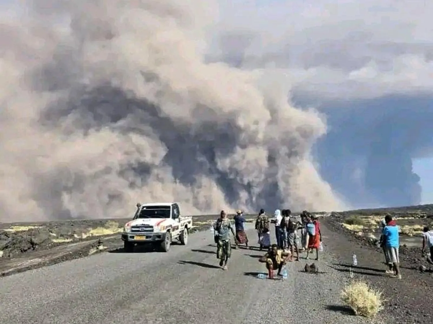 صورة وزعها المكتب الإعلامي لحكومة إقليم عفر لأشخاص يراقبون ثوران البركان هايلي غوبي في شمال شرقي إثيوبيا (أ.ب)