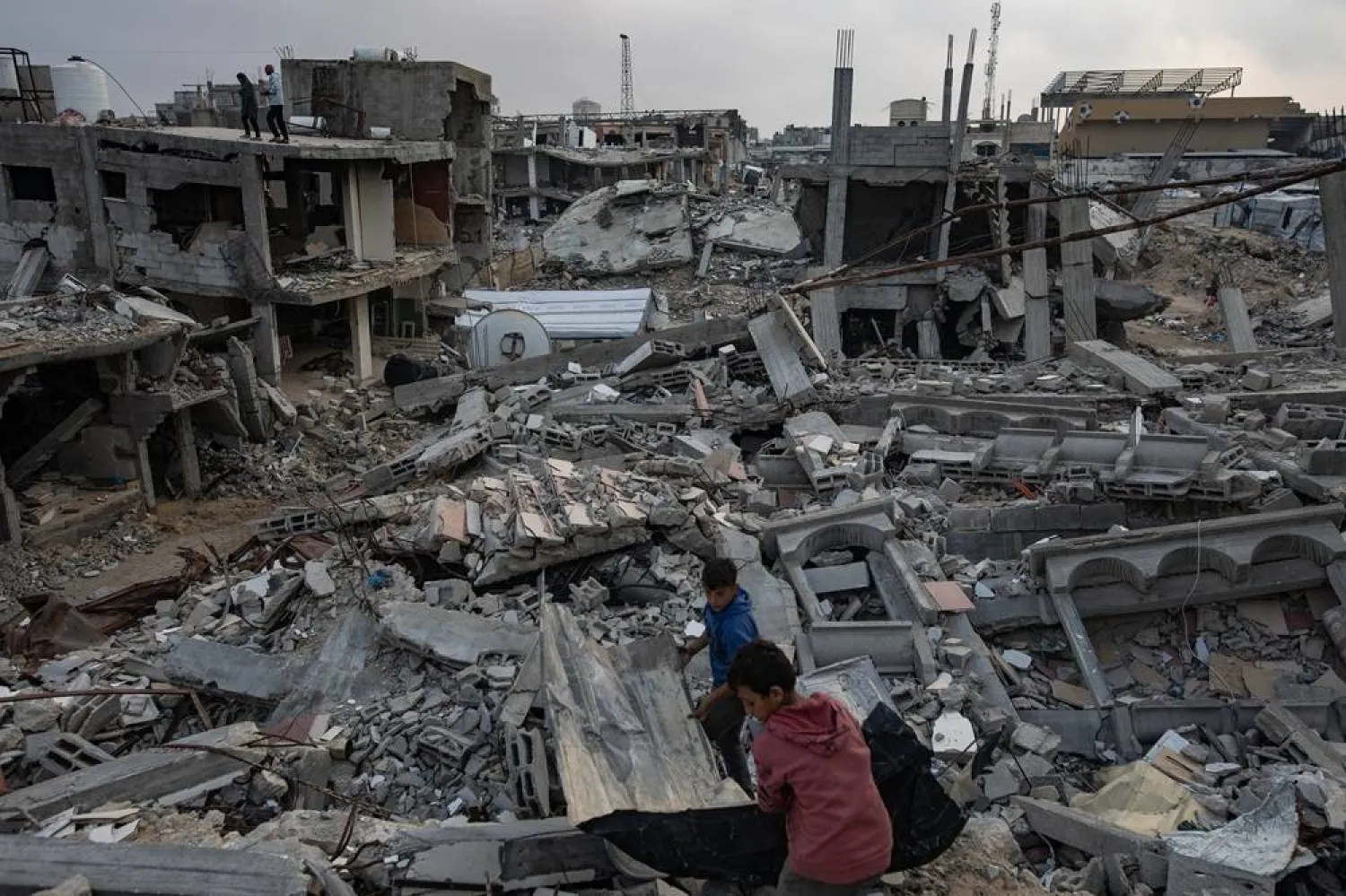 Palestinians walk among the ruins of their destroyed homes in Khan Younis, southern Gaza Strip, 24 November 2025. (EPA)