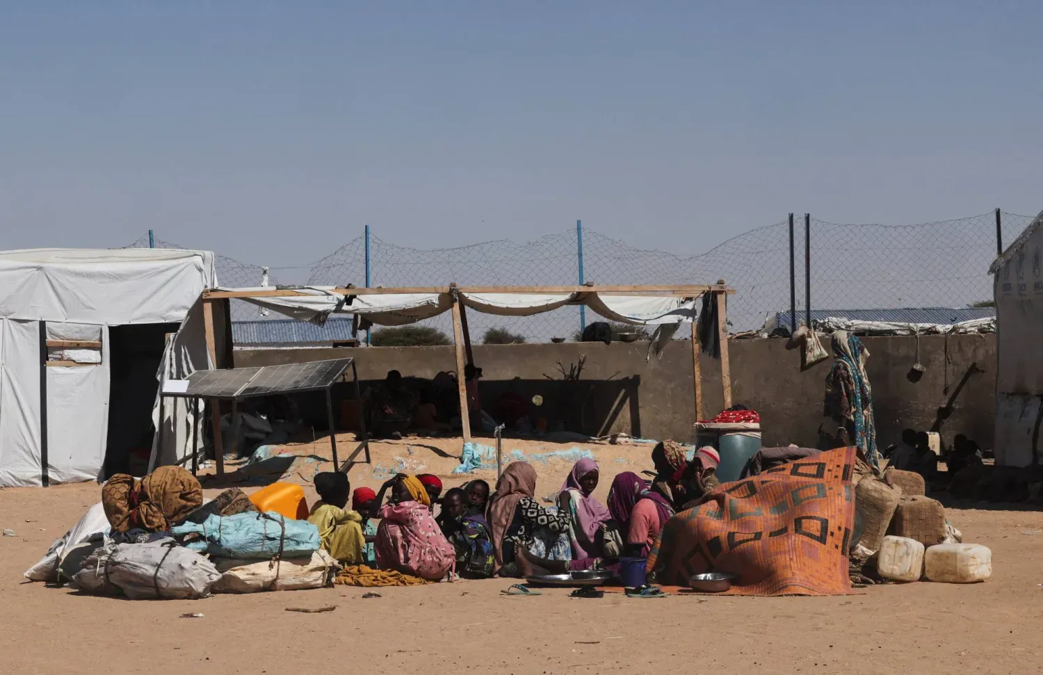 Sudan ordusu ile HDK arasında devam eden çatışmalardan kaçarak kısa süre önce Faşir’den gelen ve Çad'ın doğusundaki bir kampta yerde oturan Sudanlı mülteciler, 23 Kasım 2025 (Reuters)