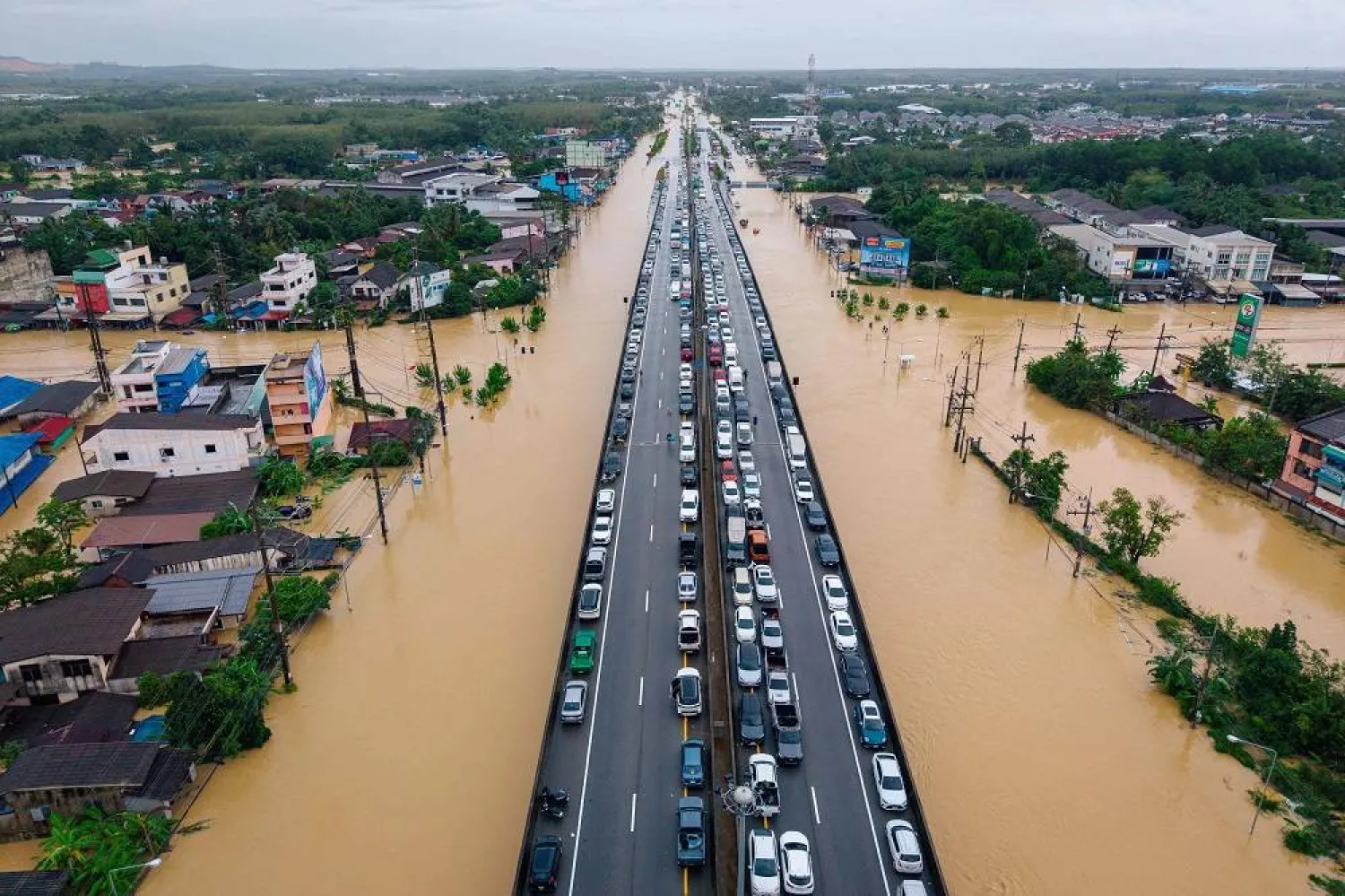 This aerial photo taken on November 25, 2025 shows vehicles parked on an elevated road to keep them out of flood waters in Hat Yai in Thailand's southern Songkhla province, as severe flooding affected thousands of people in the country's south following days of heavy rain. (AFP)