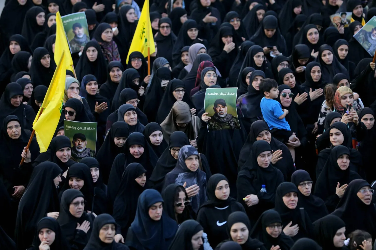 Mourners carry pictures of Haitham Tabtabai, who was killed in an Israeli strike a day earlier, during his funeral in Beirut's southern suburbs on November 24, 2025. (Photo by Ibrahim AMRO / AFP)