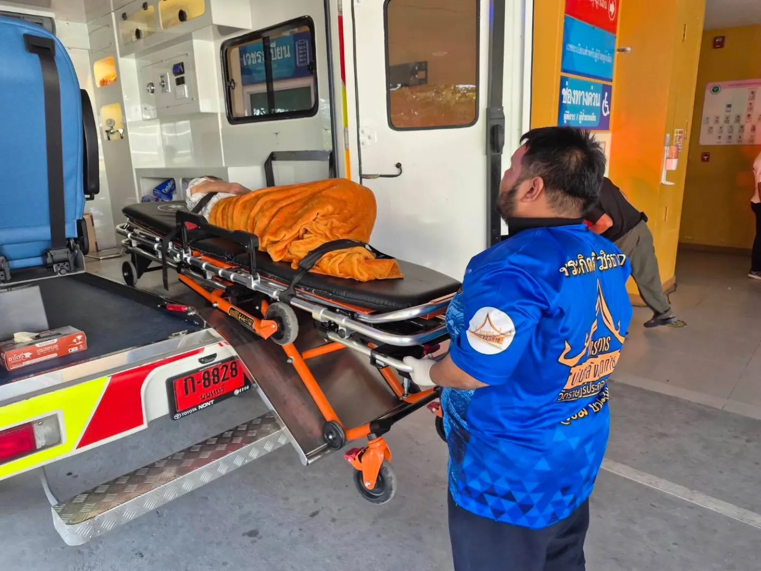 مسعف ينقل السيدة إلى سيارة الإسعاف بعد اكتشاف أنها لا تزال على قيد الحياة (أ.ب)