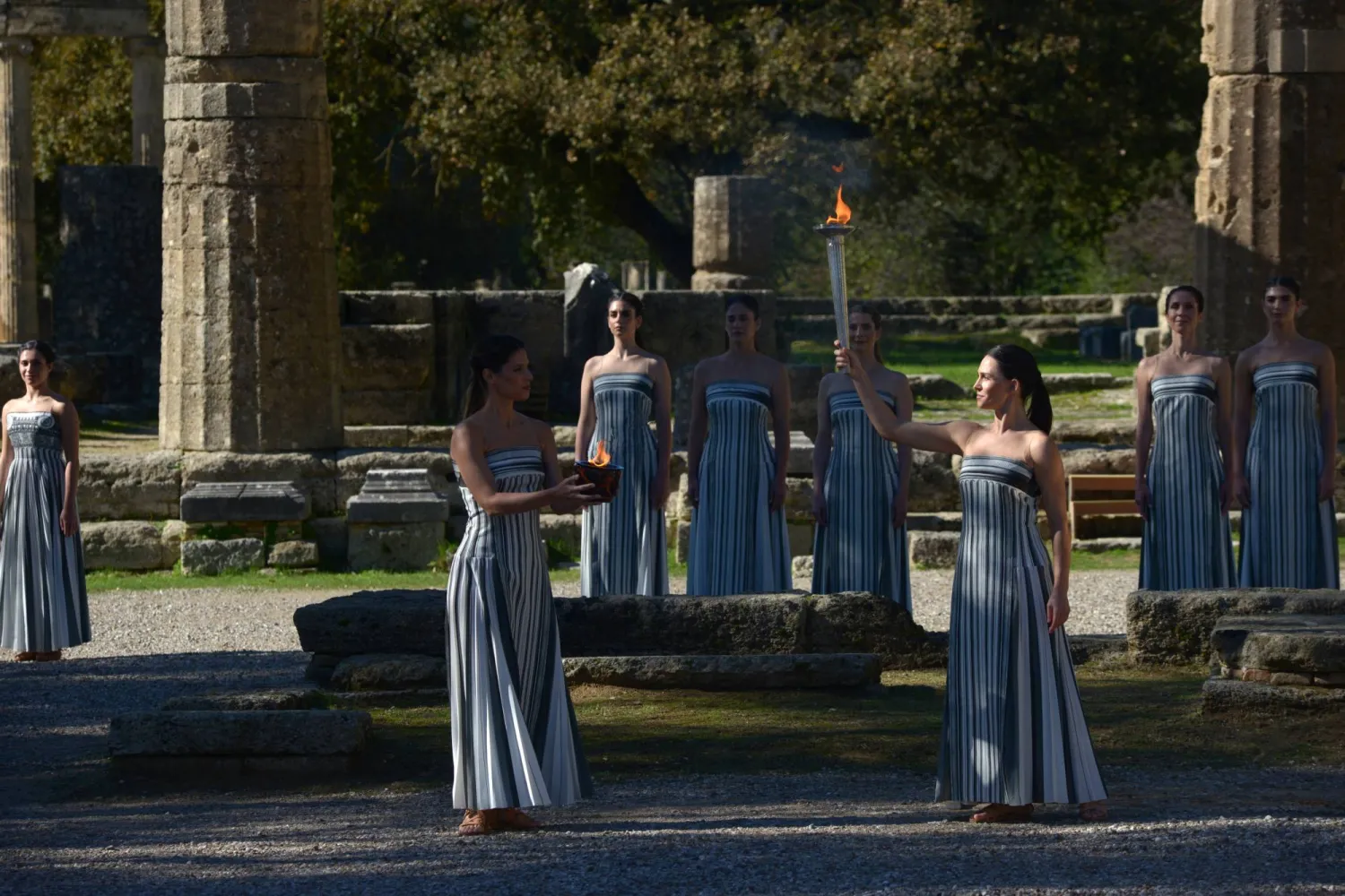 Greek actress Mary Mina (C-R), playing the role of High Priestess, holds the flame during the rehearsal of the Olympic flame lighting ceremony for the Milano Cortina 2026 Winter Olympics at the Ancient Olympia site in southern Greece, 24 November 2025. EPA/DIMITRIS PAPAIOANNOU