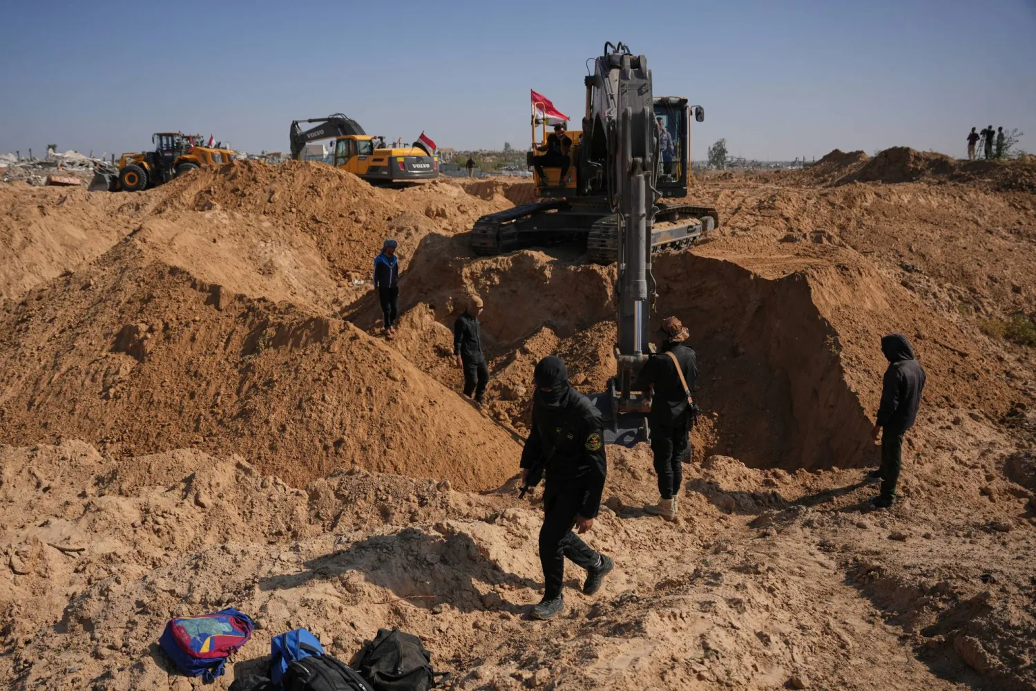 مقاتلون من «الجهاد الإسلامي» وعمال مصريون يبحثون عن جثث رهائن إسرائيليين شمال النصيرات بقطاع غزة 22 نوفمبر 2025 (أ.ب)