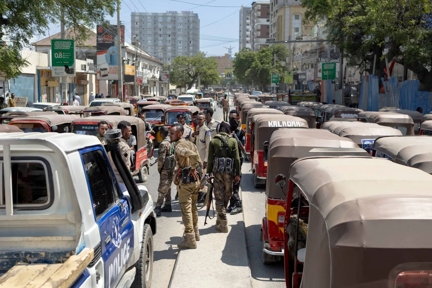  يسير ضباط شرطة صوماليون على طول حاجز وسط الطريق خلال دوريتهم في شارع مزدحم بمقديشو.. 10 نوفمبر 2025 (أ.ف.ب)