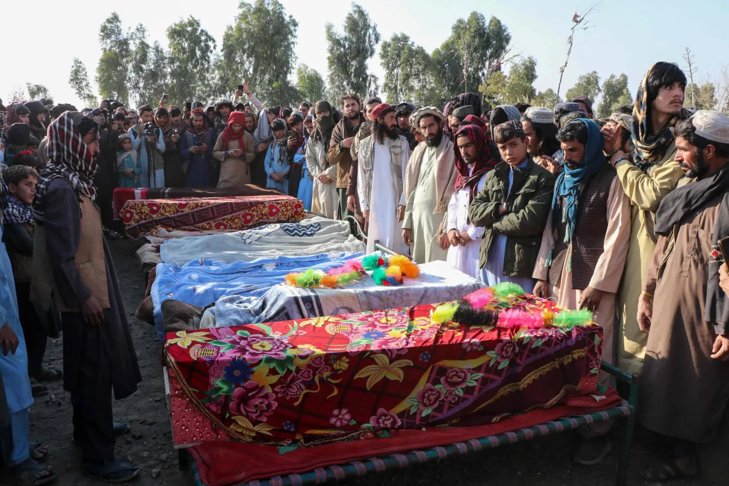 تجمع مشيعون أفغان وأقارب الضحايا خلال مراسم دفن جماعي لتسعة أطفال وامرأة قُتلوا في غارة جوية ليلة أمس في منطقة جوربوز بإقليم خوست (أ.ف.ب)
