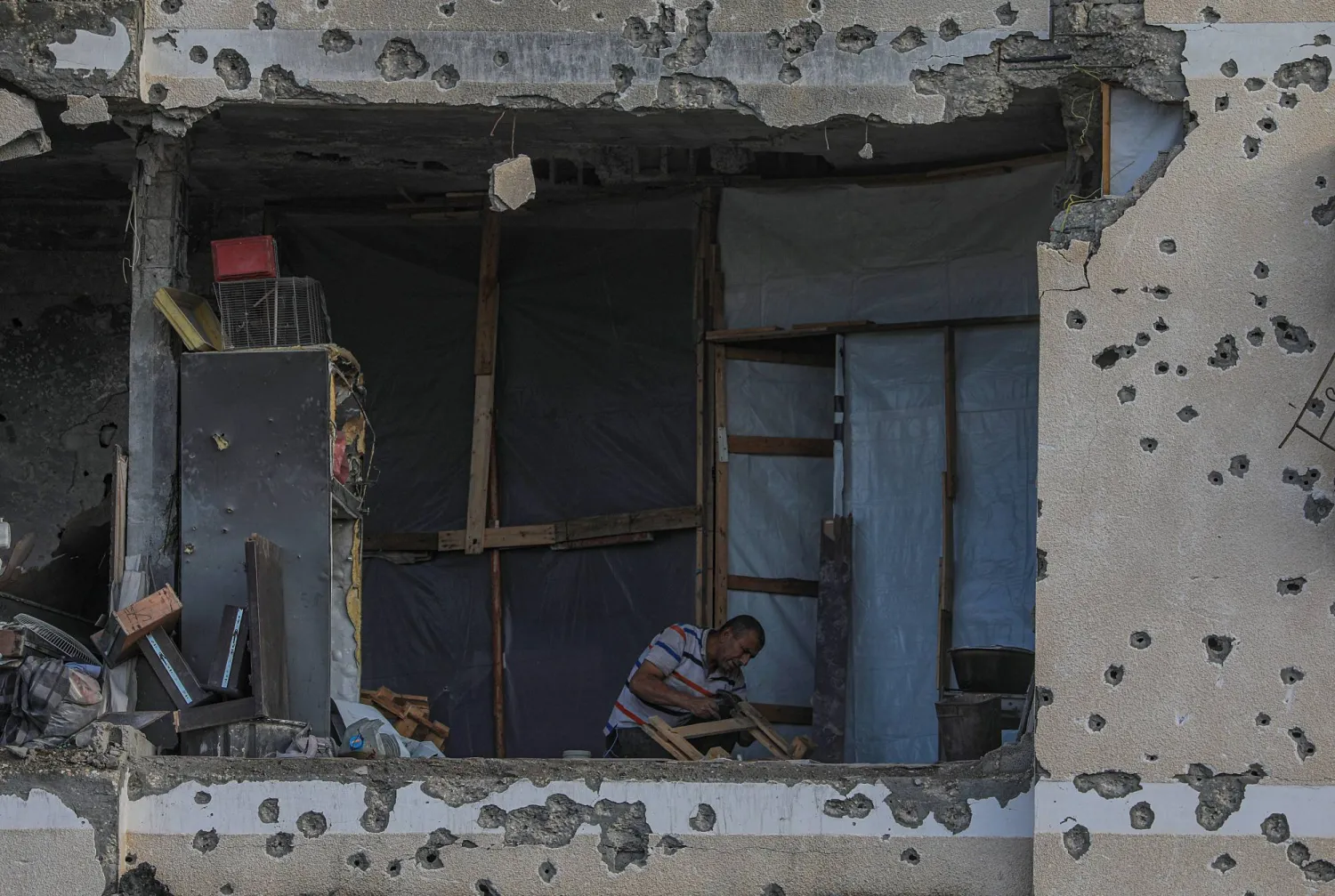 فلسطيني في منزل عائلته المدمر خلال يوم ممطر في مدينة غزة الثلاثاء (إ.ب.أ)