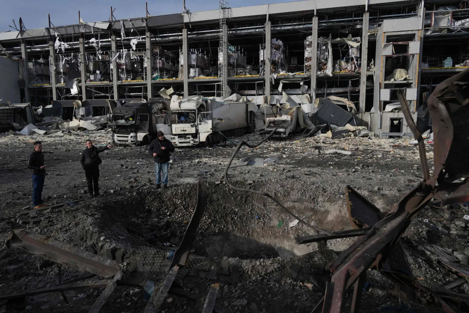 ضباط إنفاذ القانون يفحصون حفرة بجوار مركز اللوجيستيات المتضرر بشدة لسوبر ماركت في أعقاب الضربات الروسية على كييف 25 نوفمبر 2025 (أ.ف.ب)