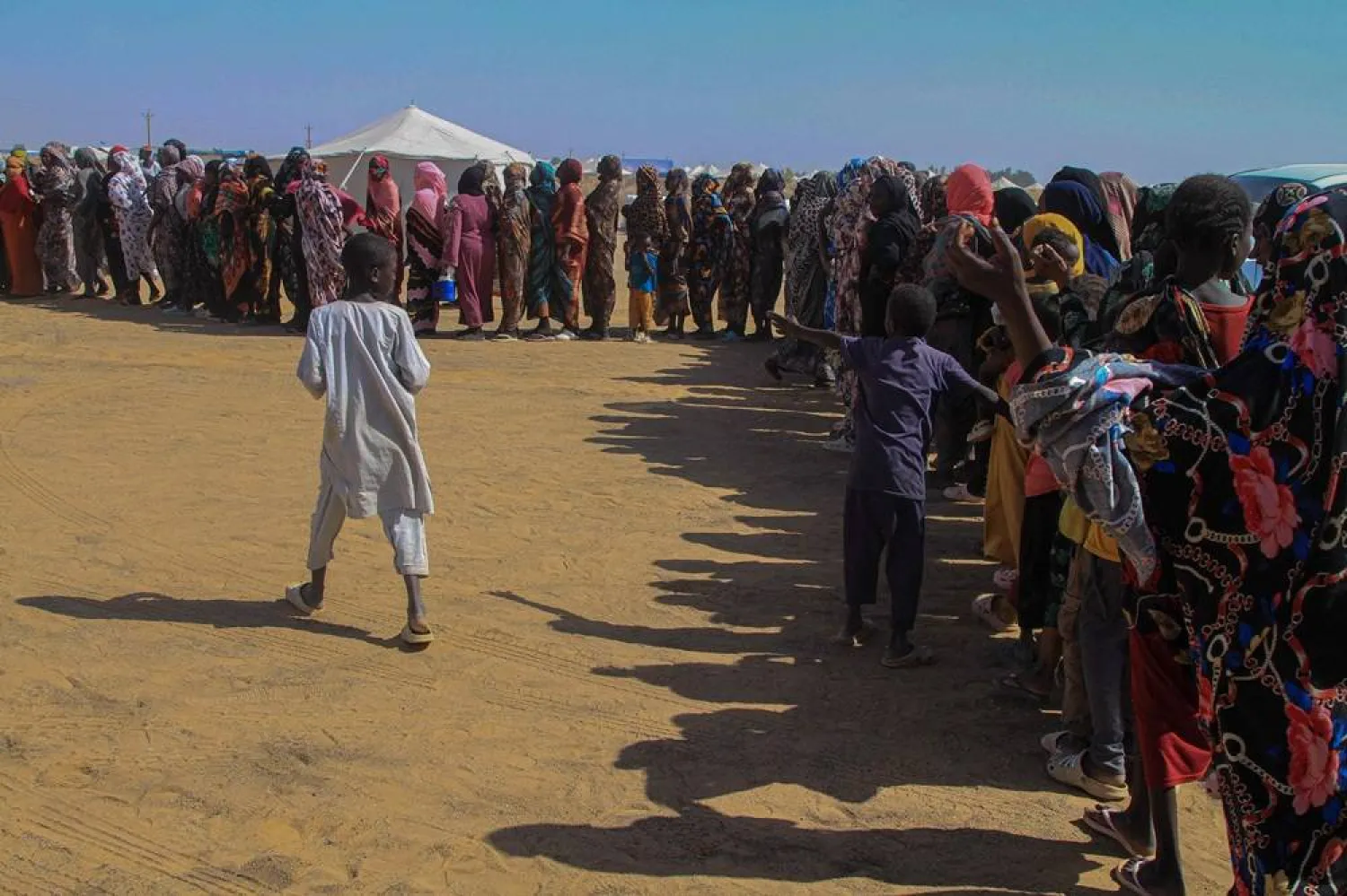Sudanese women who fled el-Fasher line up to receive humanitarian aid at the Al-Afad camp for displaced people in the town of Al-Dabba, northern Sudan, on November 25, 2025. (AFP)