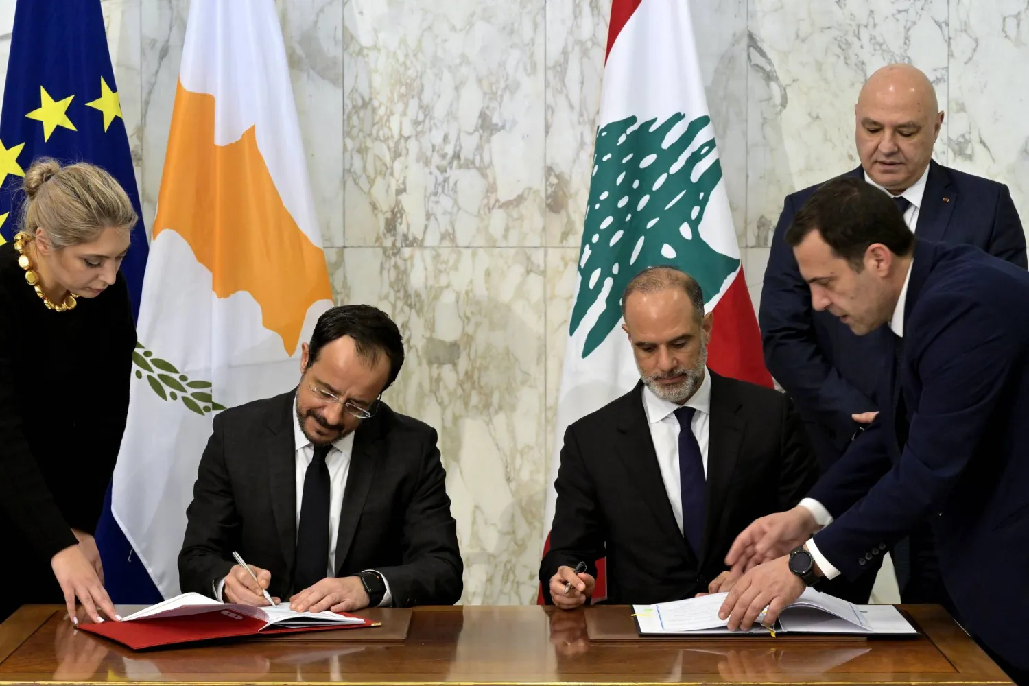 الرئيس القبرصي نيكوس خريستودوليدس يوقع مع وزير الأشغال اللبناني فايز رسامني الاتفاقية الحدودية بحضور الرئيس اللبناني جوزيف عون (د.ب.أ)