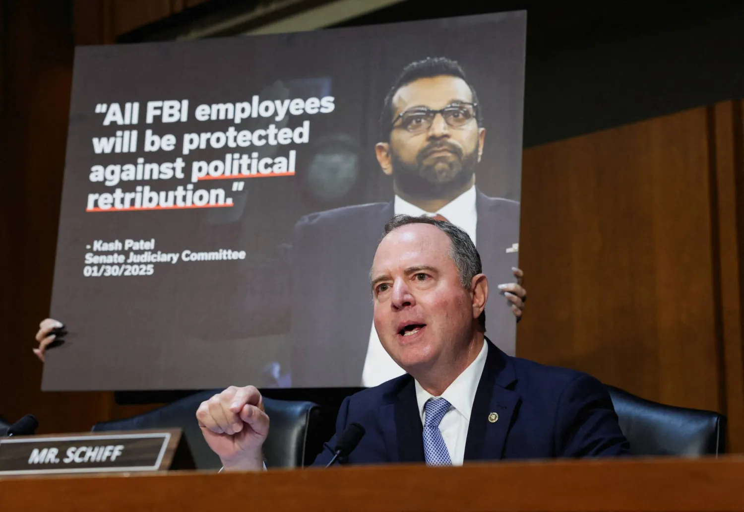 السيناتور الأميركي آدم شيف (ديمقراطي من كاليفورنيا) يتحدث أمام لافتة عليها صورة مدير «مكتب التحقيقات الفيدرالي» كاش باتيل في أثناء إدلائه بشهادته أمام لجنة القضاء في مجلس الشيوخ بشأن الإشراف على «مكتب التحقيقات الفيدرالي» على تلة الكابيتول في العاصمة واشنطن - 16 سبتمبر 2025 (رويترز)