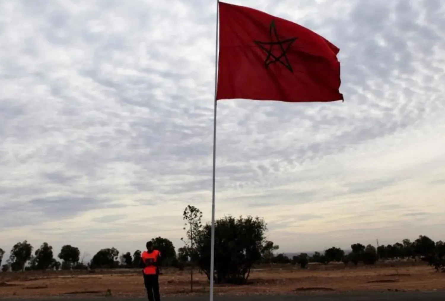 File photo of a police officer standing near a Moroccan national flag near the main stadium during preparations for the FIFA Club World Cup in Agadir, December 10, 2013. REUTERS/Amr Abdallah Dalsh
