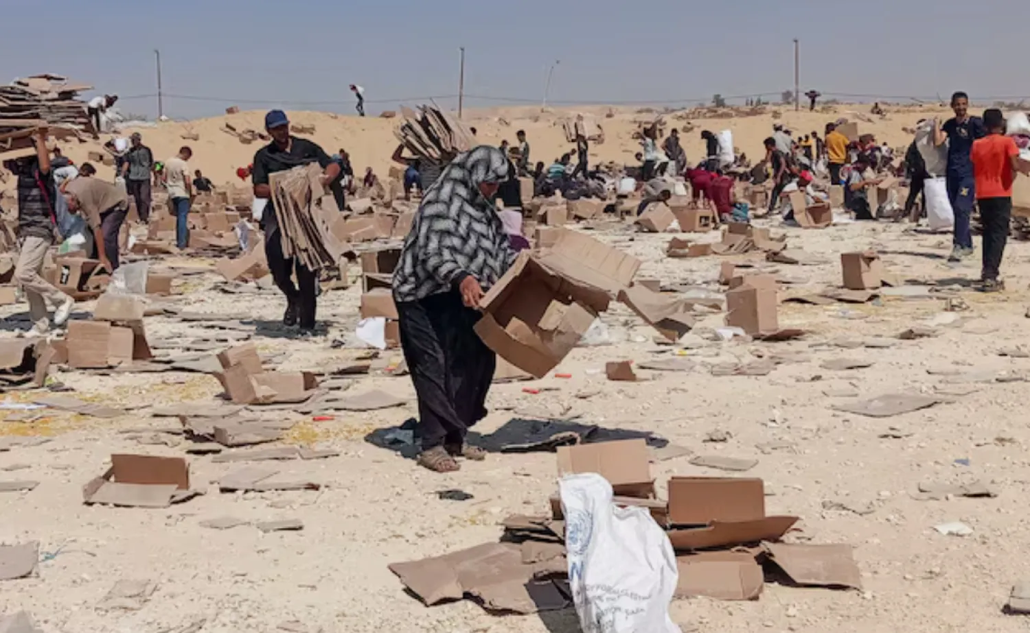Palestinians gather to collect what remains of relief supplies from the distribution center of the US-backed Gaza Humanitarian Foundation, in Rafah, in the southern Gaza Strip, June 5, 2025. REUTERS/Stringer/File Photo 