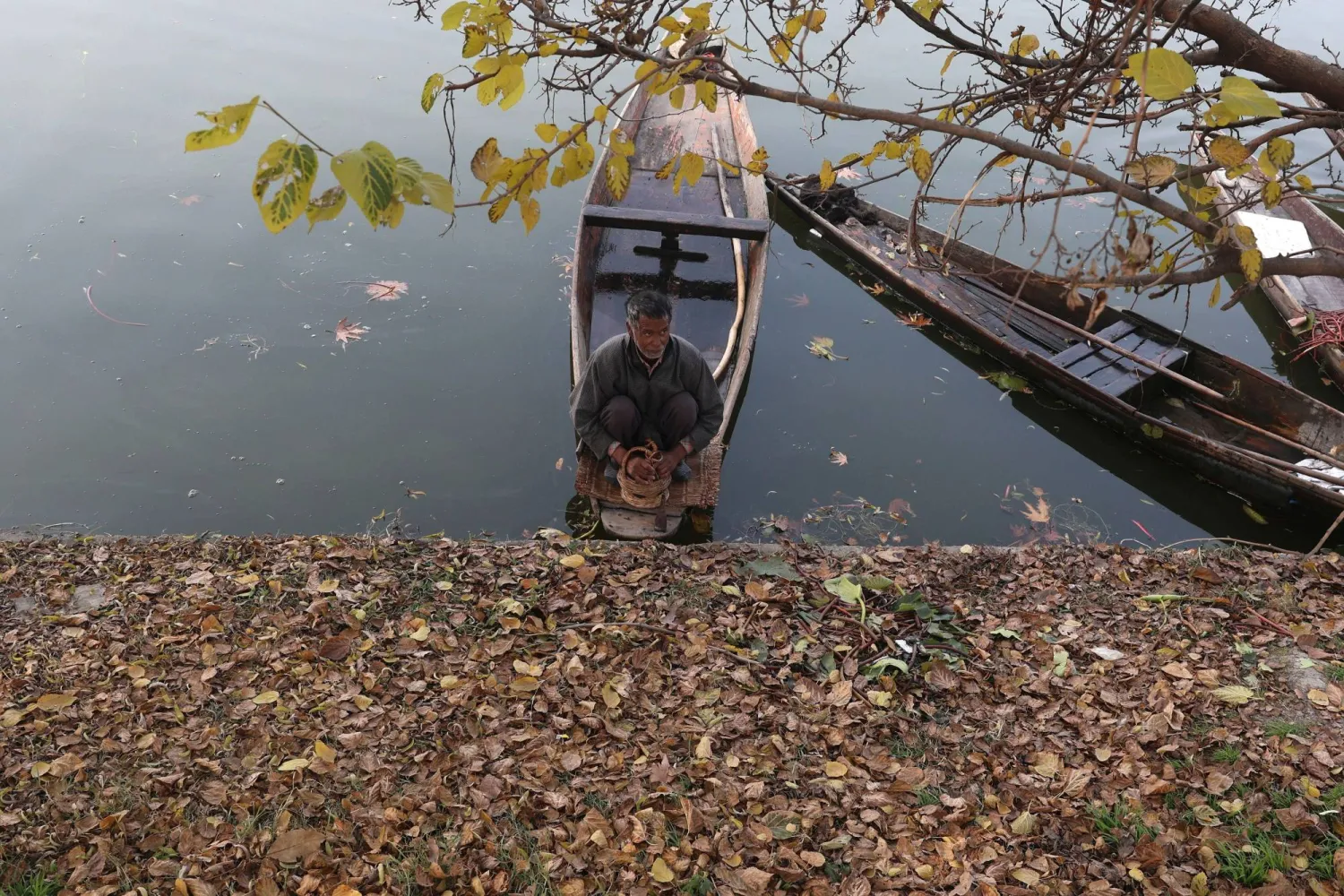 A person sits in a small boat on Dal Lake in Srinagar, the summer capital of Indian Kashmir, 26 November 2025. EPA/FAROOQ KHAN
