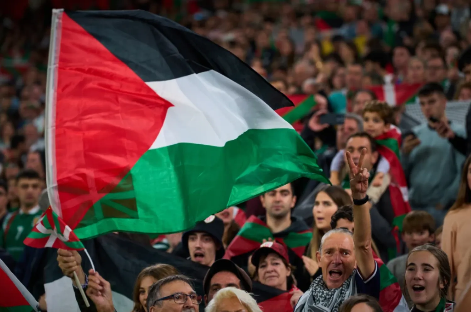 Fans wave Palestinian flags during a friendly match between a selection of Palestinian players and a group of Spanish players from the Basque Country, held to protest Israel’s military actions in Gaza, in Bilbao, Spain, Saturday, Nov. 15, 2025. (AP Photo/Miguel Oses)

