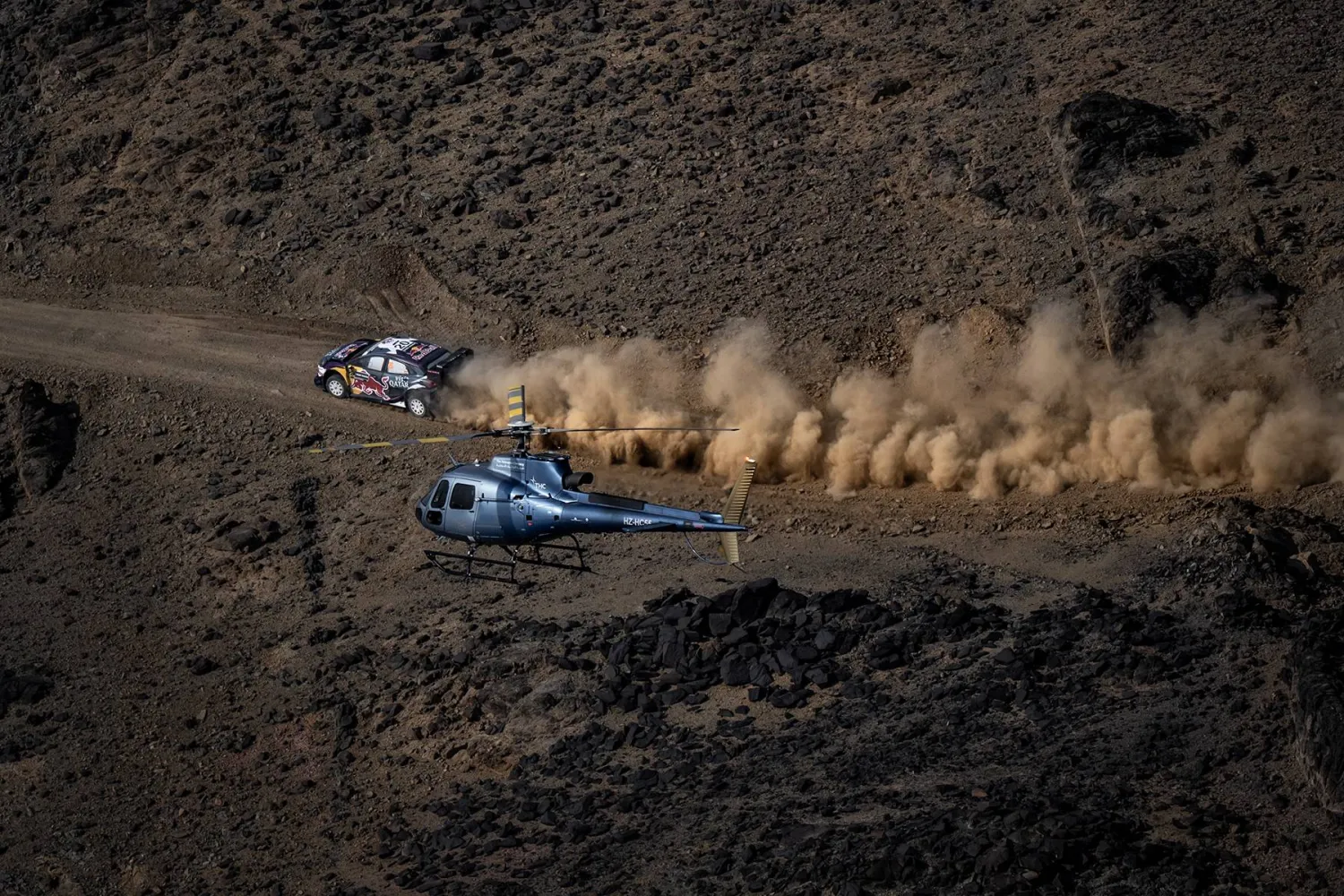 سيارة أحد المتسابقين تشق طريقها عبر الجبال وسط مراقبة المروحية (الشرق الأوسط)