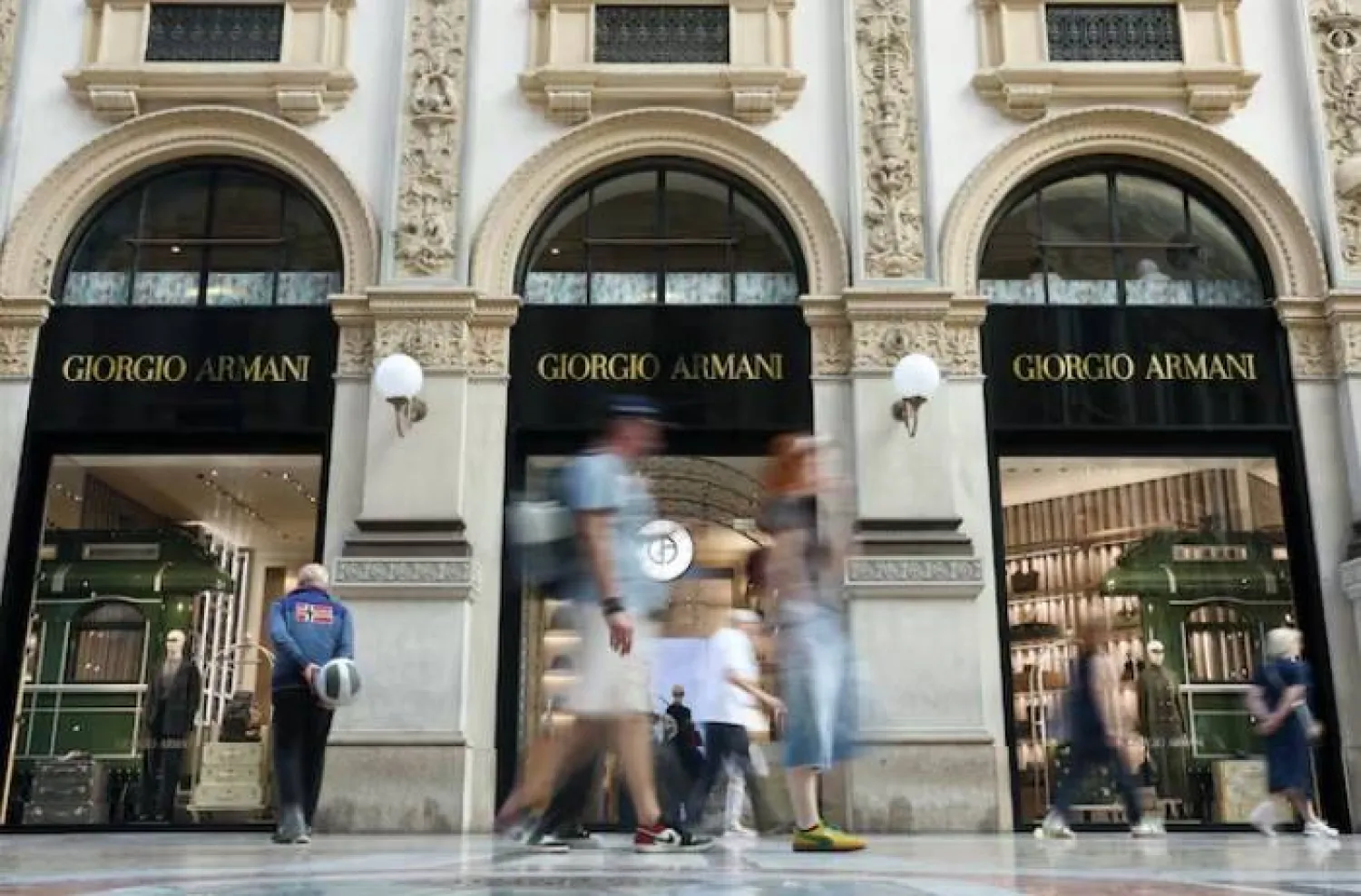 People walk past a Giorgio Armani store in Galleria Vittorio Emanuele II in Milan, Italy, September 5, 2025. REUTERS/Gonzalo Fuentes Purchase Licensing Rights
