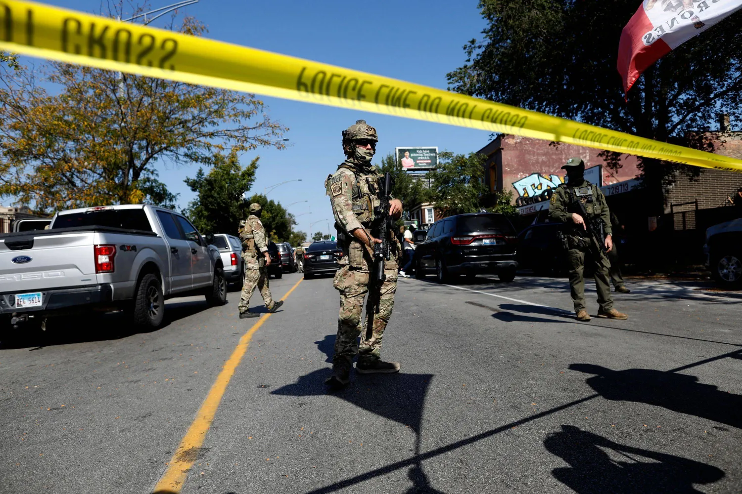 Masked US Customs and Border Protection (CBP) Border Patrol agents stand behind a police line as residents of Chicago's Brighton Park neighborhood confront law enforcement at a gas station after Immigration and Customs Enforcement (ICE) agents allegedly detained an unidentified man riding in his car, in Chicago, Illinois, on October 4, 2025. (Photo by OCTAVIO JONES / AFP)