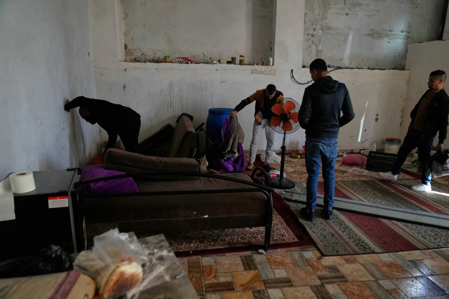 فلسطينيون يتفقدون المكان الذي قُتل فيه المنتصر بالله عبد الله ويوسف عصاعصة في جنين (أ.ب)