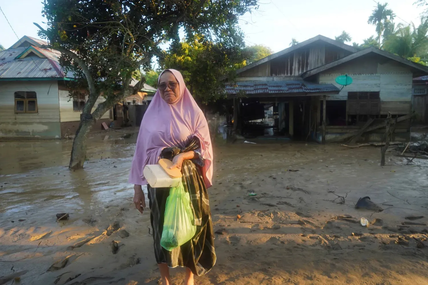 Şiddetli yağışların ardından meydana gelen ölümcül sel baskınlarından etkilenen bölgeyi ziyaret eden bir kadın (Reuters)
