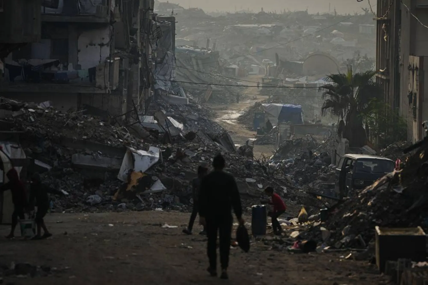  Palestinians walk through the destruction left by the Israeli air and ground offensive in Gaza City, Saturday, Nov. 29, 2025. (AP) 