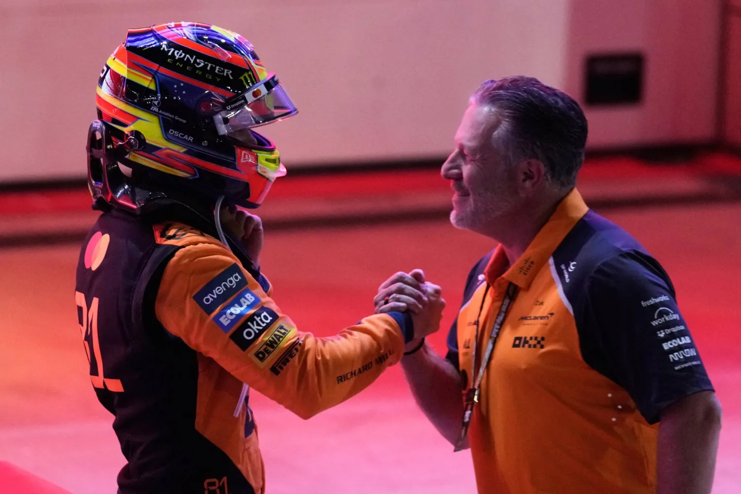  أوسكار بياستري يصافح مدير مكلارين زاك براون بعد فوزه بسباق السرعة في قطر (أ.ب)