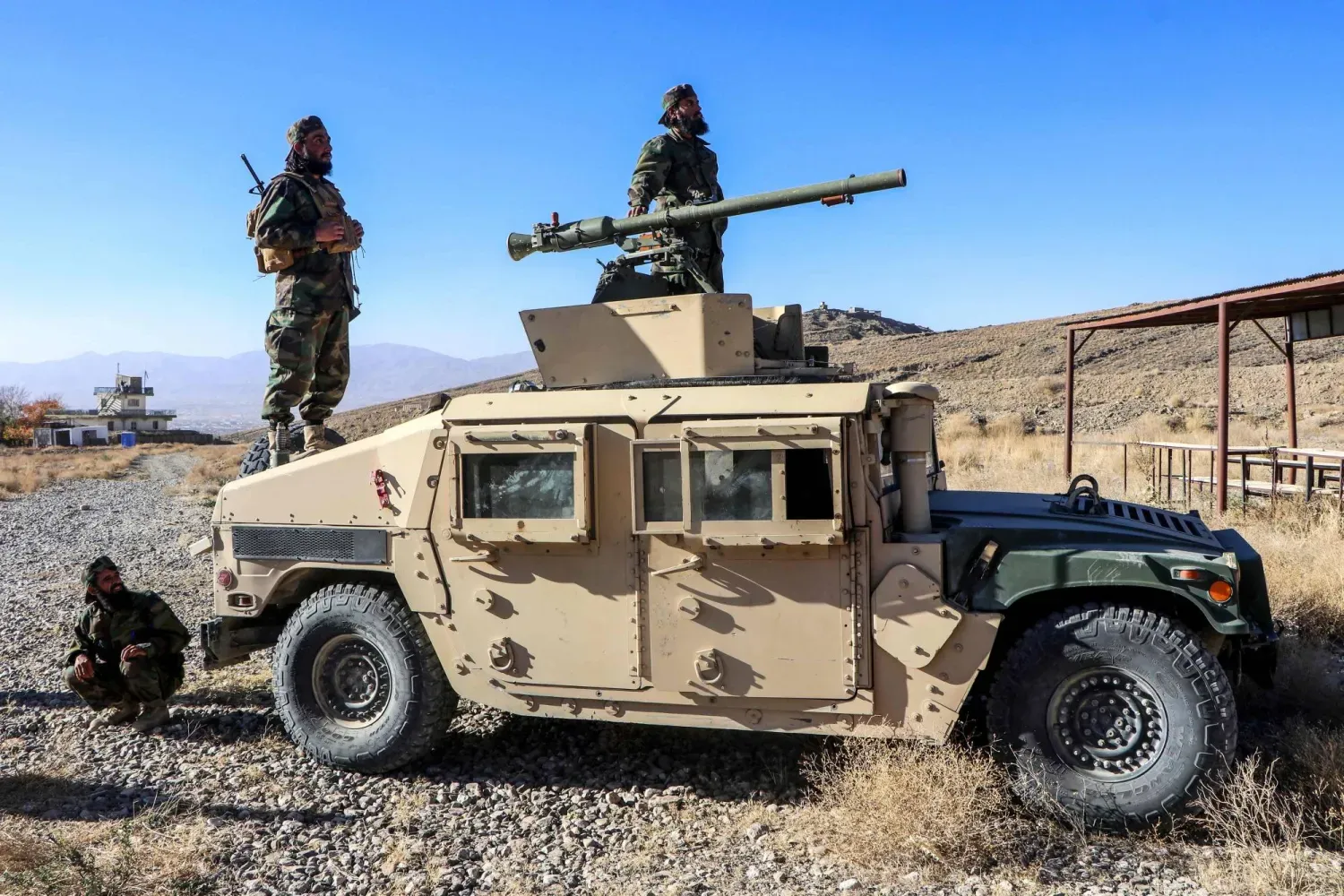 Paktiya vilayetinin Gardez kenti yakınlarındaki 203 Mansuri Kolordusu Eğitim Merkezi’nde düzenlenen mezuniyet töreninde bir askeri aracın üzerinde poz veren Taliban ordusuna yeni katılan askerler, 2 Kasım 2025 (AFP)