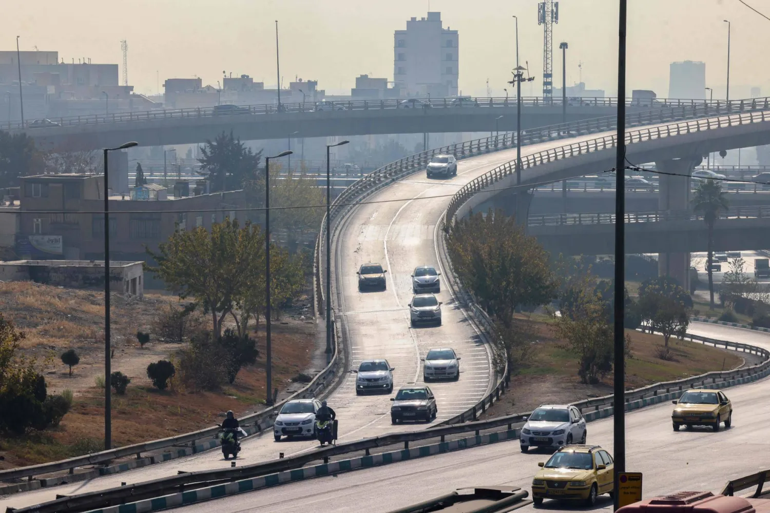Traffic moves in heavy smog in Tehran on November 29, 2025. (Photo by ATTA KENARE / AFP)