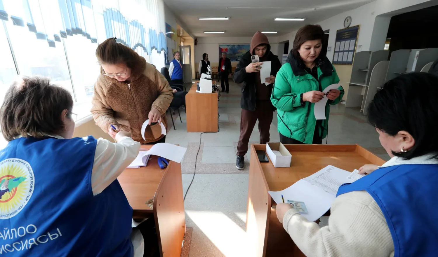 أعضاء اللجنة الانتخابية في مركز اقتراع خلال الانتخابات البرلمانية المبكرة في قرية كارا-زيغاتش قرب بيشكيك بقرغيزستان (إ.ب.أ)