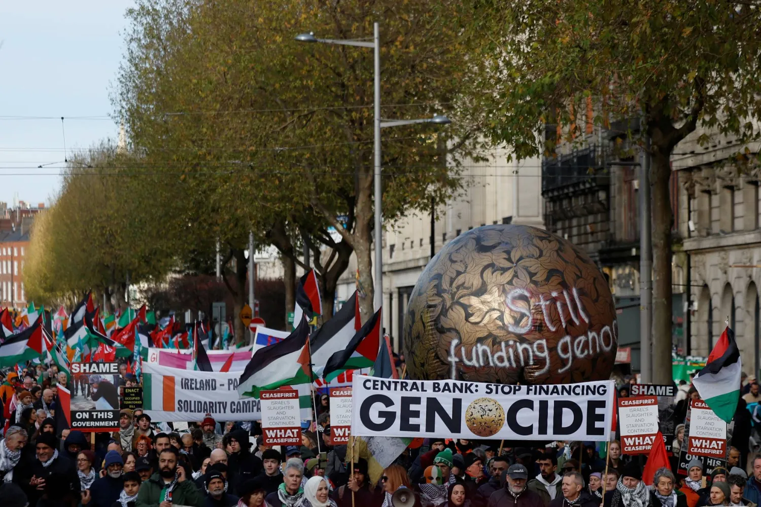 متظاهرون يرفعون أعلام فلسطين ويطالبون بوقف تمويل الإبادة في غزة خال مسيرة بيوم التضامن الدولي مع الشعب الفلسطيني في دبلن (رويترز)  