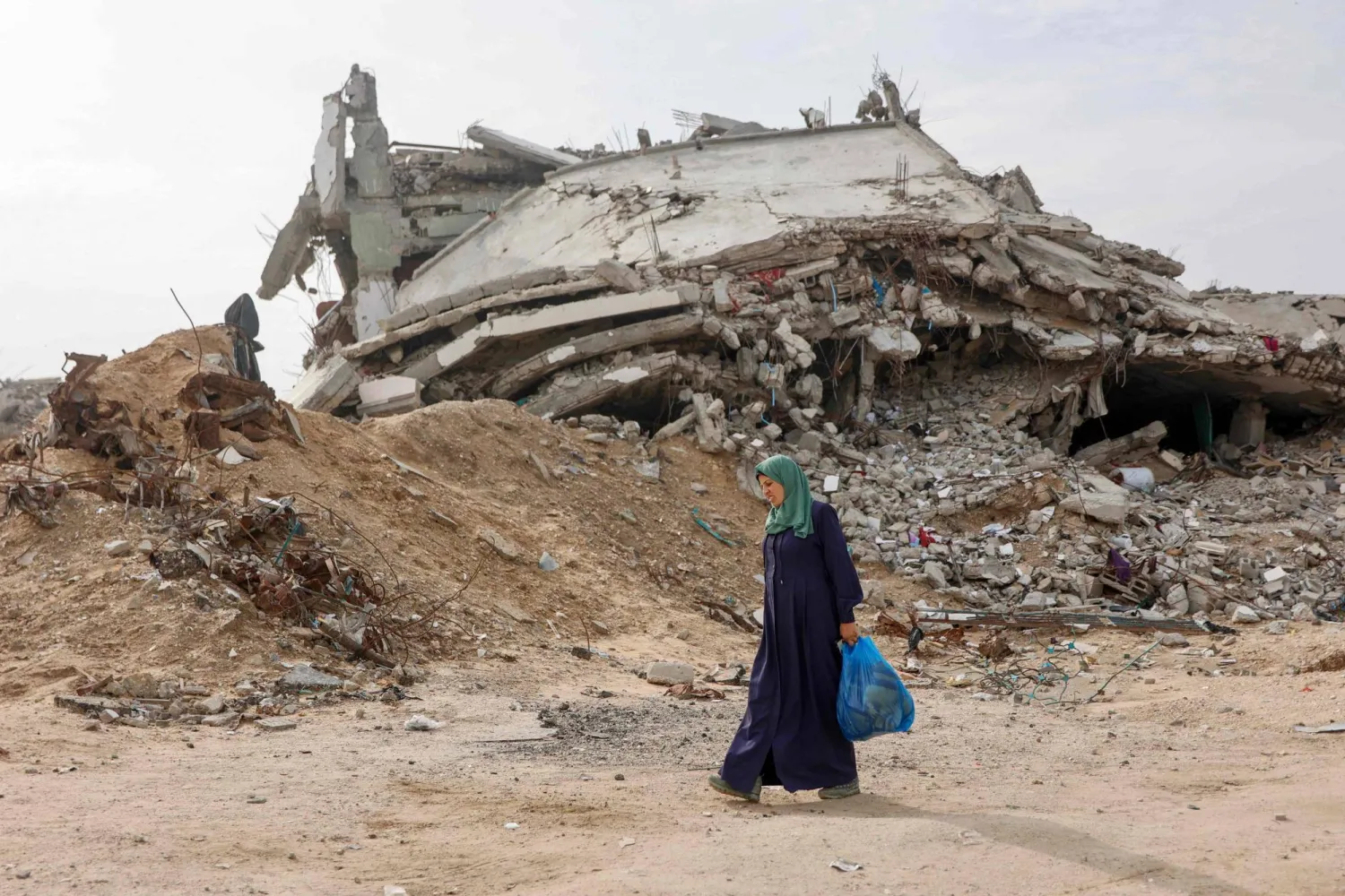 فلسطينية نازحة تمر أمام مبنى مدمر في حي تل الهوى جنوب مدينة غزة 29 نوفمبر 2025 (أ.ف.ب)