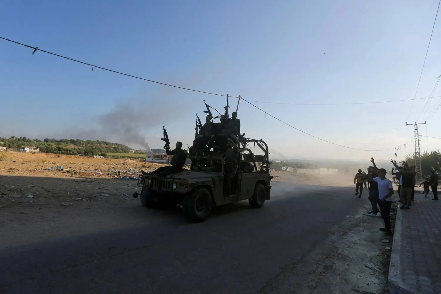 Palestinian gunmen riding in an Israeli military vehicle they seized during the October 7, 2023 attack (Reuters). 