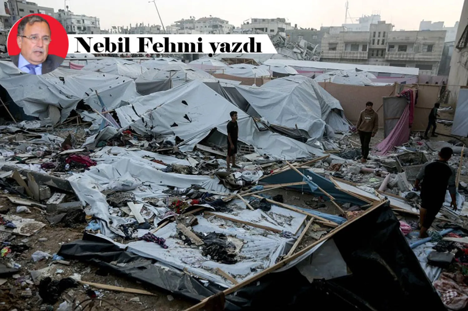 Filistinliler, İsrail ordusunun Gazze'ye düzenlediği askeri operasyonun ardından yerinden edilmiş kişilerin çadırlarını kurdukları bölgeyi inceliyor, 22 Kasım 2025 (AFP)