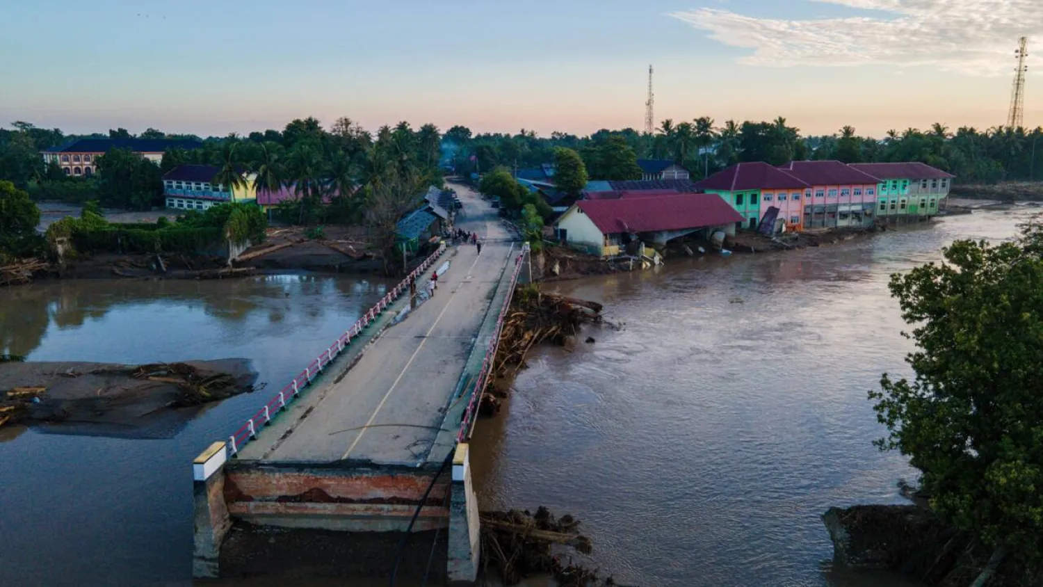 A bridge damaged by flash floods is seen during sunrise in Meureudu, Pidie Jaya district in Indonesia's Aceh province on November 30. CHAIDEER MAHYUDDIN / AFP
