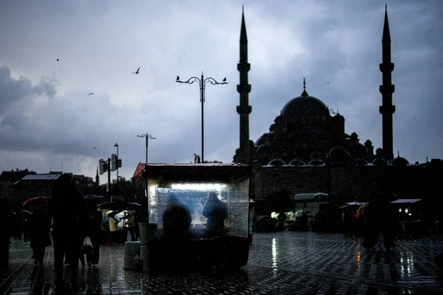 Vendors sell roasted chestnuts near the New Mosque in a rainy day in Istanbul, Türkiye, Sunday, Nov. 30, 2025. (AP) 