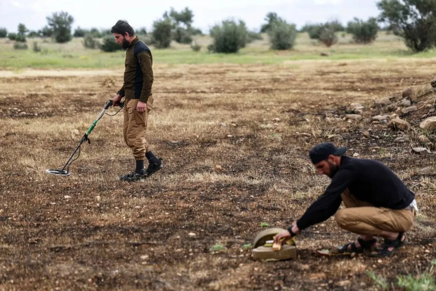 Members of Syria's Ministry of Defense clear landmines south of Idlib. (AP)