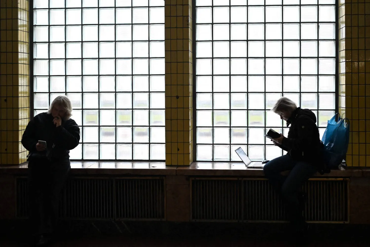 Two women use their mobile phones at a metro station in Kyiv on November 27, 2025, amid the Russian invasion of Ukraine. (AFP) 