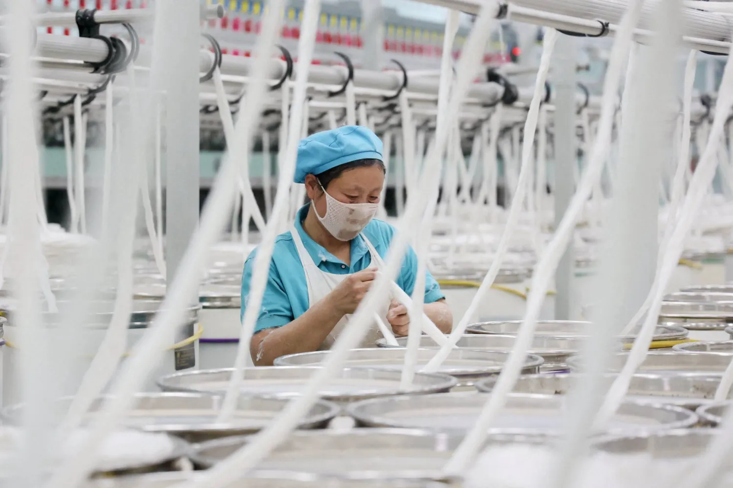عاملة في مصنع للنسيج بمدينة بينتشو شرق الصين (أ.ف.ب)