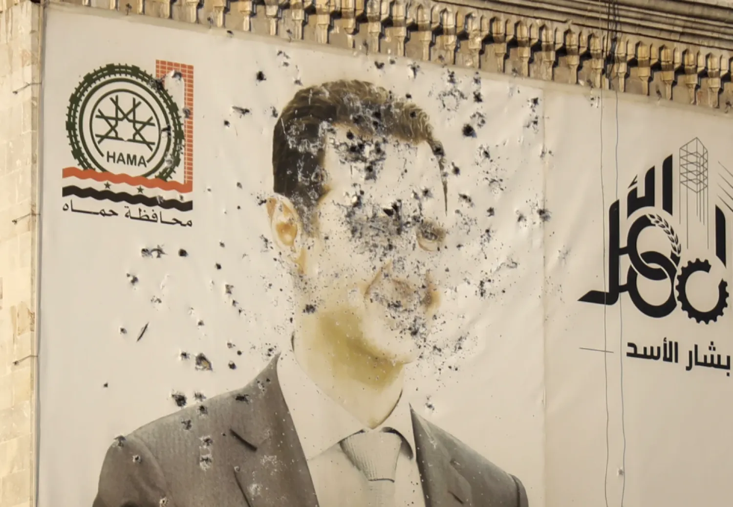 An image of Syrian President Bashar Assad, riddled with bullets, is seen on the facade of the provincial government office in the aftermath of the opposition’s takeover of Hama, Syria, Friday, Dec. 6, 2024. (AP Photo/Omar Albam)
