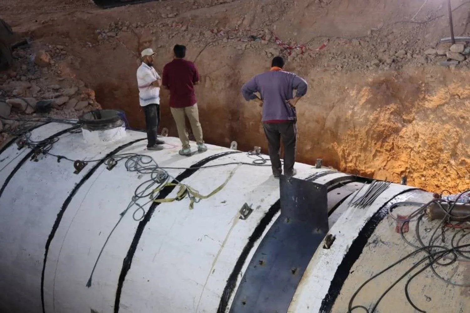 فنيون بجهاز «النهر الصناعي» في ليبيا يعملون على توصيل خط فرعي (النهر الصناعي)