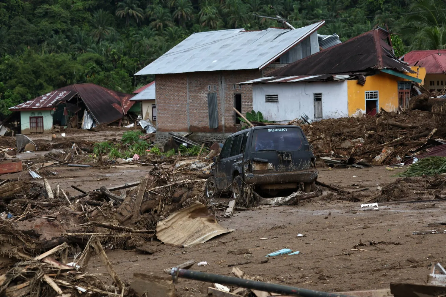 A car stuck in the mud sits among debris at an area hit by deadly flash floods following heavy rains in Palembayan, Agam regency, West Sumatra province, Indonesia, December 2, 2025. REUTERS/Willy Kurniawan