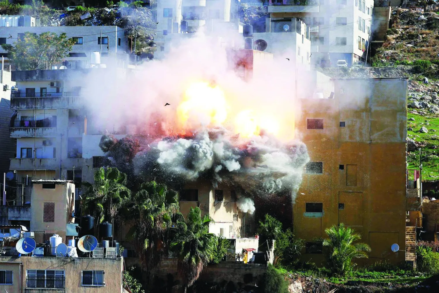 لحظة تفجير منزل الفلسطيني المعتقل عبد الكريم صنوبر في نابلس بالضفة الغربية بعد أن فجّرته قوات إسرائيلية أمس (أ.ف.ب)