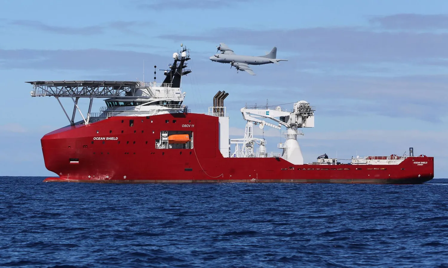 (FILES) This handout file photo taken and released on April 9, 2014 by Australian Defence shows a Royal Australian Air Force AP-3C Orion flying past Australian Defense Vessel Ocean Shield on a mission to drop sonar buoys to assist in the acoustic search for missing Malaysia Airlines flight MH370 in the southern Indian Ocean.  (Photo by Handout / AUSTRALIAN DEFENCE / AFP)