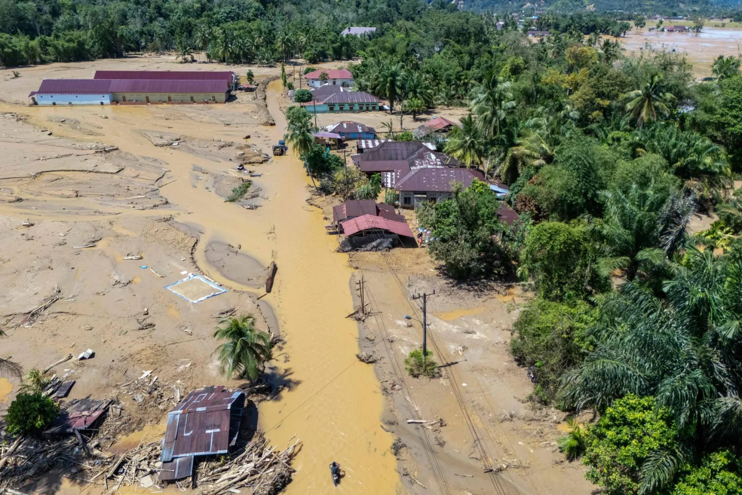 This picture shows an aerial view of villagers wading through the mudflow to find a shelter in the aftermath of flash floods in Tukka village, Central Tapanuli, North Sumatra province, on December 3, 2025. (AFP)