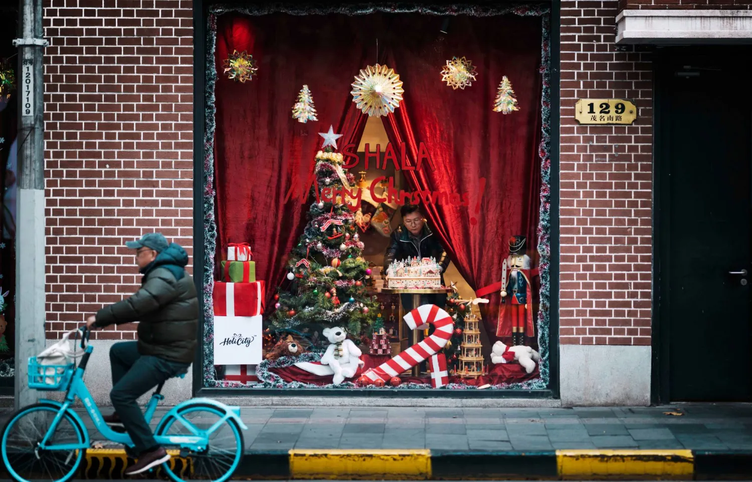 رجل ينسق واجهة أحد المتاجر في مدينة شنغهاي الصينية بمناسبة أعياد رأس السنة (إ.ب.أ)