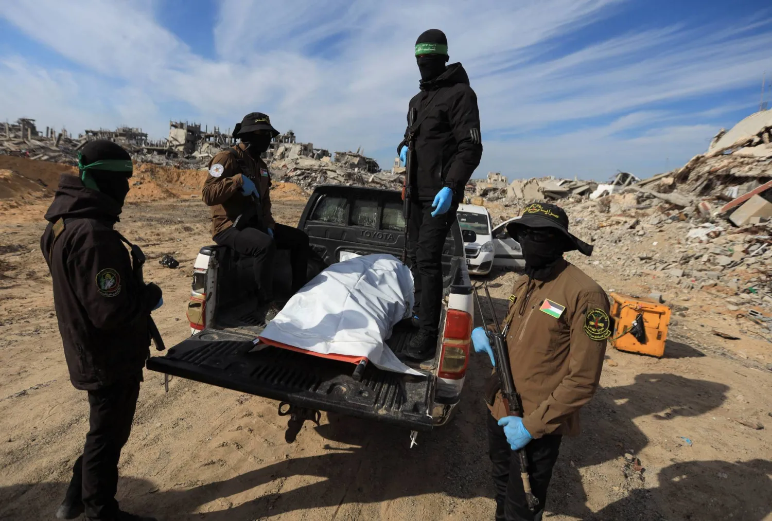 مسلحون من حركتي «حماس» و«الجهاد» يعثرون على جثة خلال عملية البحث عن جثث الرهائن القتلى في بيت لاهيا شمال قطاع غزة (رويترز)