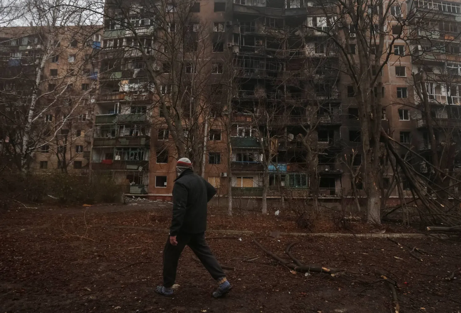 أحد السكان يسير بالقرب من مبنى سكني تضرر خلال غارة روسية على مدينة كراماتورسك في منطقة دونيتسك بأوكرانيا 2 ديسمبر 2025 (رويترز)