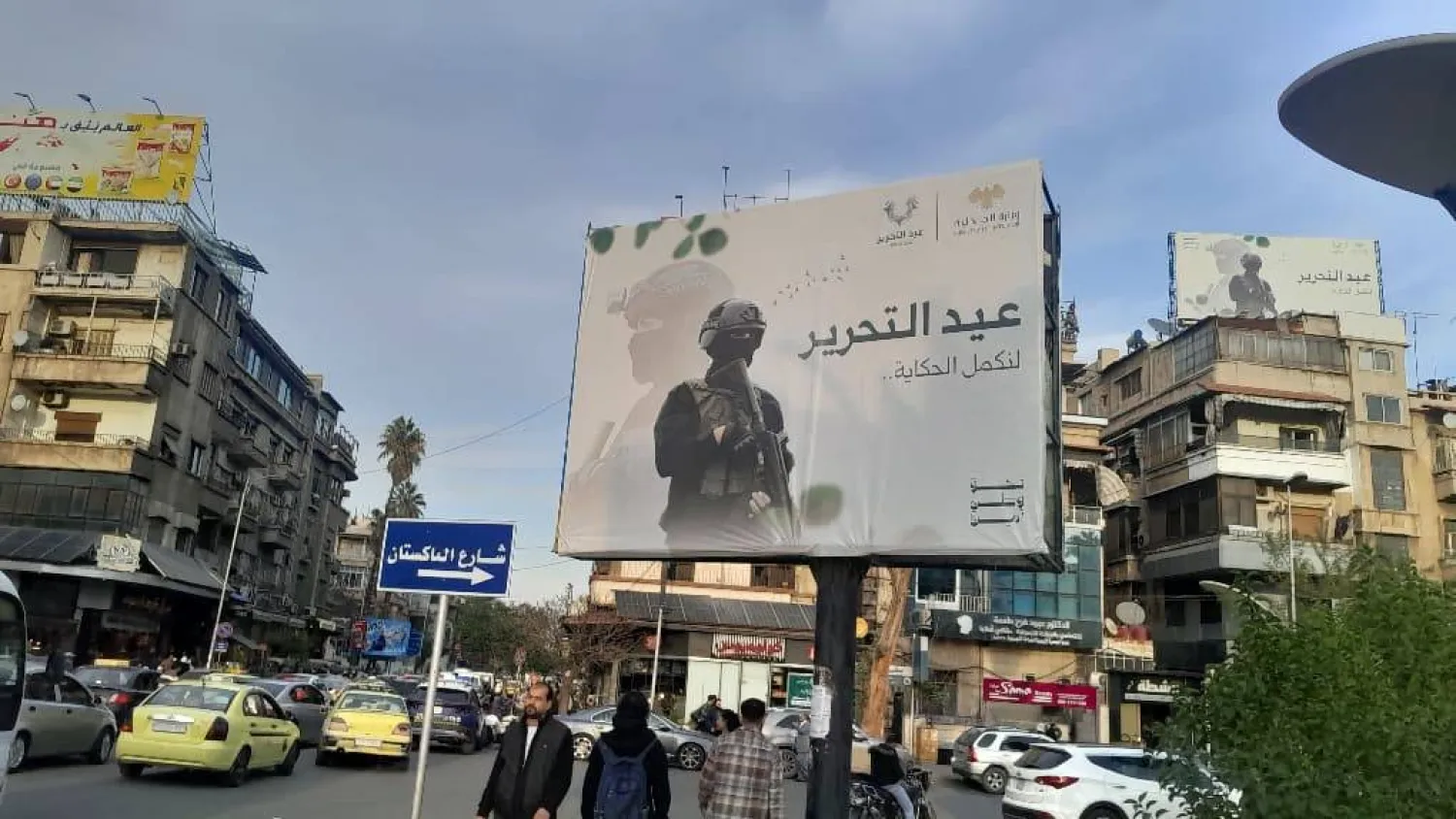 من لافتات ذكرى التحرير وسقوط نظام الأسد في شوارع دمشق (الشرق الأوسط)